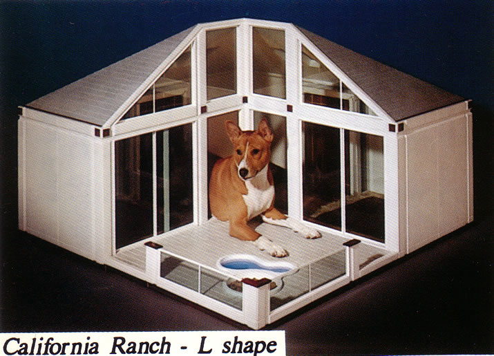 A dog relaxing inside the California Ranch pet home, with glazed doors, a pitched roof, and a front deck